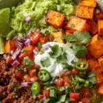 Sweet Potato Taco Bowls with seasoned meat and fresh toppings in a rustic bowl
